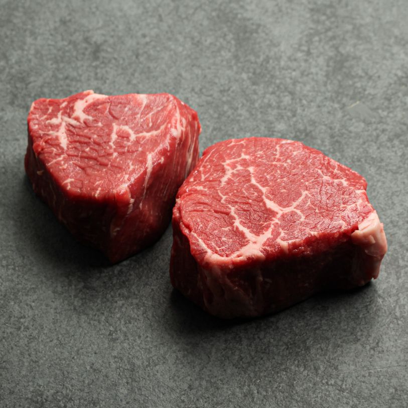 Angled image of two, 6 oz baseball medallions cut from AAA Canadian beef.