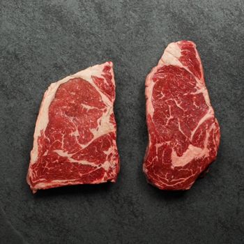 overhead view of two raw rib eye steaks