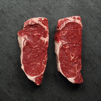 overhead view of two raw new york steaks