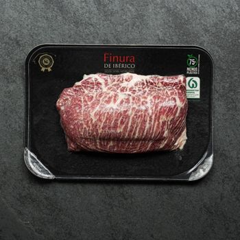 overhead view of raw iberico presa on black slate