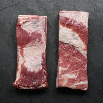 overhead view of two raw pieces of skin-on pork belly