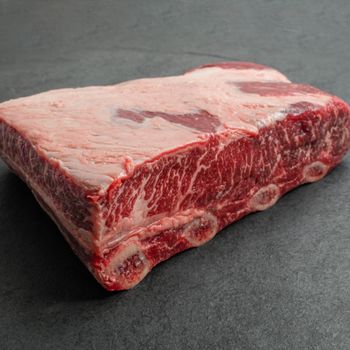 overhead image of a piece of raw beef short ribs with 4 bones