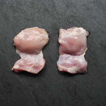 overhead view of two raw boneless skinless chicken thighs