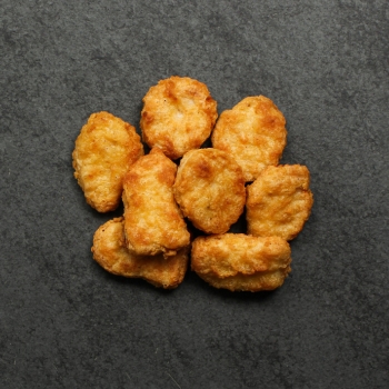 Overhead view of cooked Chicken Fritters on a black slate.