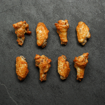 Overhead image of eight, fully cooked chicken wings
