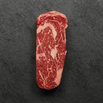 overhead view of a raw, well-marbled grass fed ribeye steak