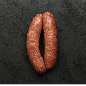 overhead image of two raw hot italian pork sausages