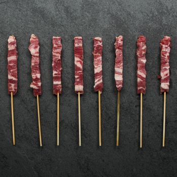overhead view of raw mini lamb skewers