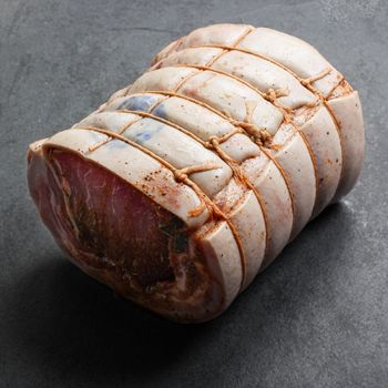 angled view of a raw, seasoned and tied porchetta roast