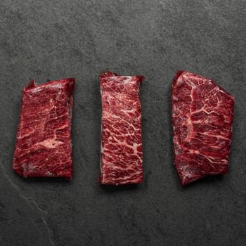 overhead view of three raw American wagyu beef flat iron steak random portions