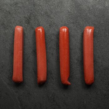 overhead view of four raw wagyu beef frankfurters