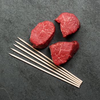 overhead of beef tenderloin with skewers