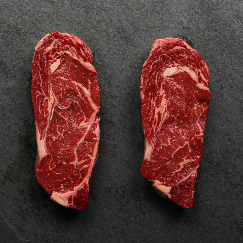 overhead view of two raw Argentinian rib eye steaks