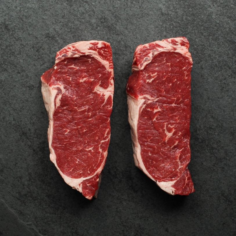 overhead view of two raw new york steaks