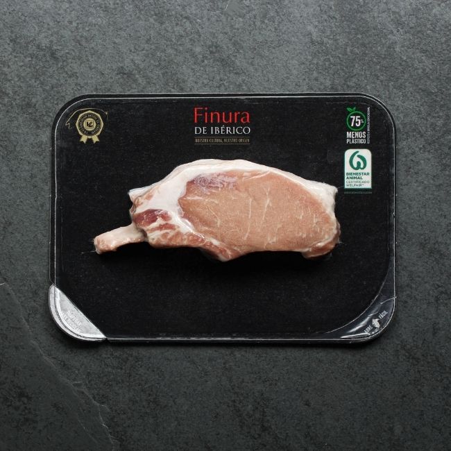 overhead view of a vacuum packaged raw Iberico pork rib chop with a Frenched bone