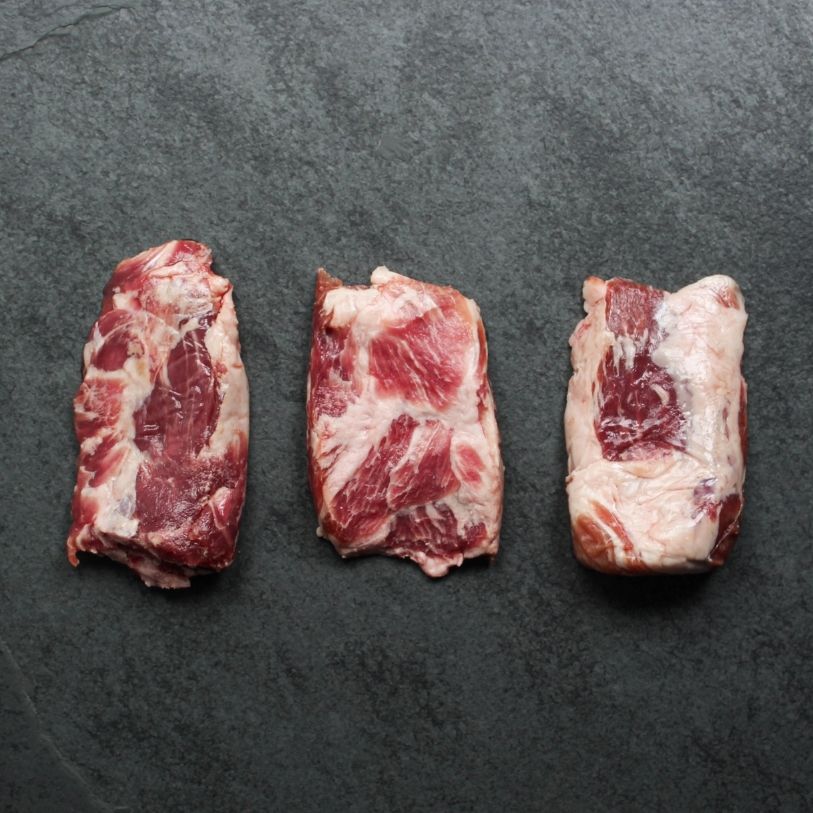 overhead view of three raw pieces of Iberico pork pluma