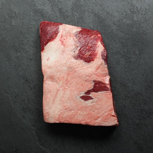 overhead image of a piece of raw beef short ribs with 4 bones