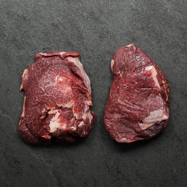 overhead view of two raw, richly-marbled beef cheeks