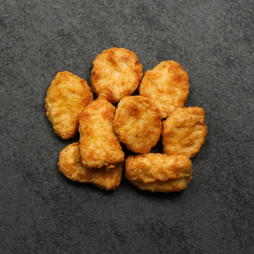 Overhead view of cooked Chicken Fritters on a black slate.