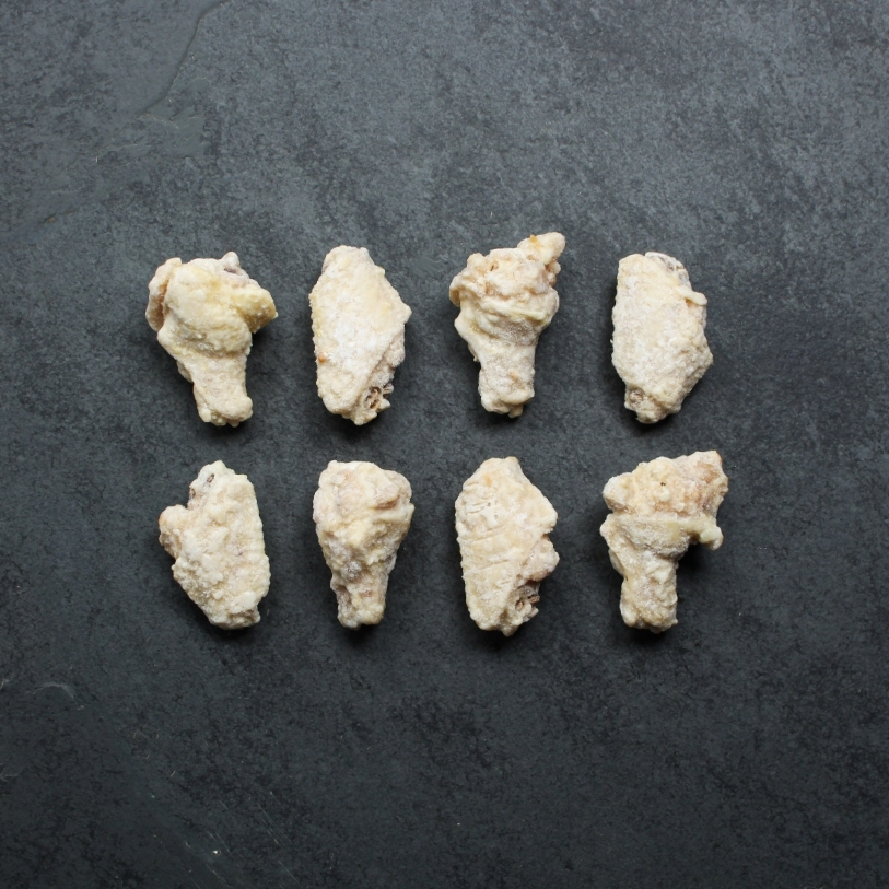 Overhead image of eight, frozen fully cooked chicken wings