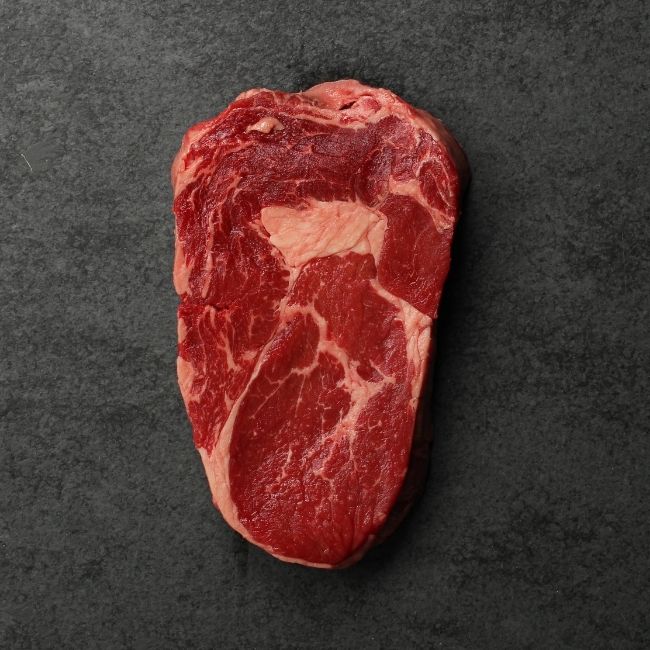 overhead image of a raw grass fed rib eye steak