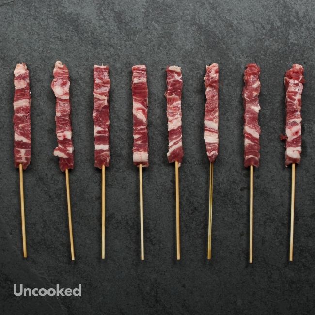 overhead view of raw mini lamb skewers