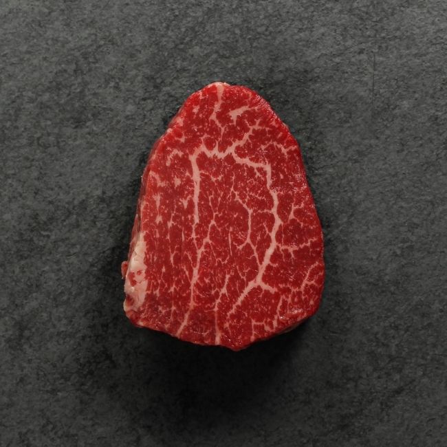 overhead view of a raw heavily marbled American-wagyu beef hybrid filet mignon