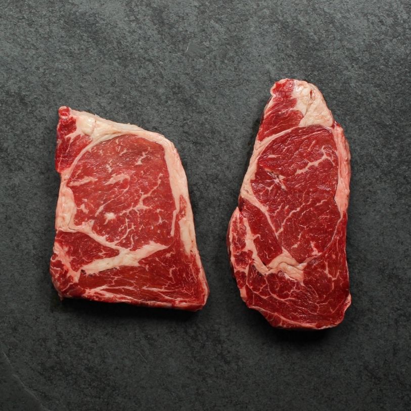overhead view of two raw rib eye steaks