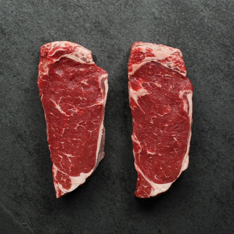 overhead view of two raw new york steaks