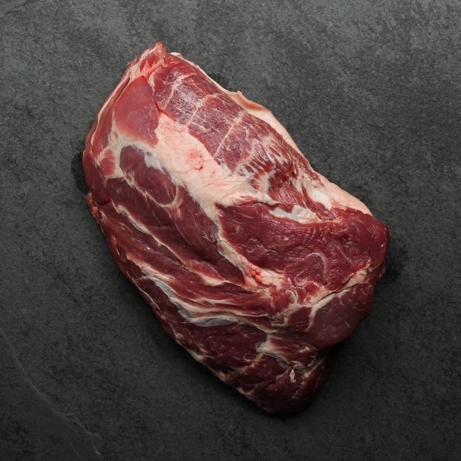 Overhead image of the underside of a raw boneless pork butt roast