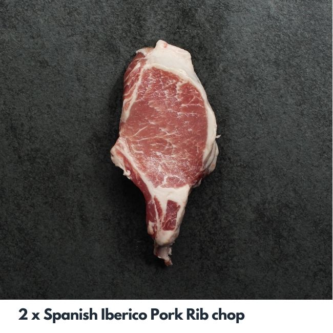 Overhead image of a raw well-marbled, bone-in Spanish Iberico pork chop