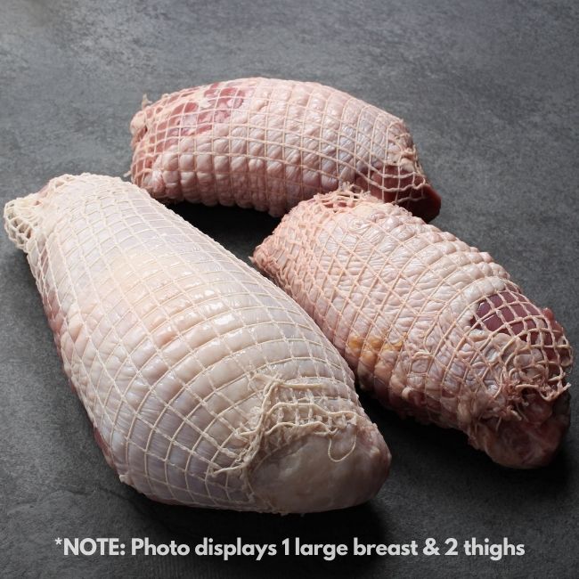 angled view of a raw netted turkey breast and two raw netted turkey thighs