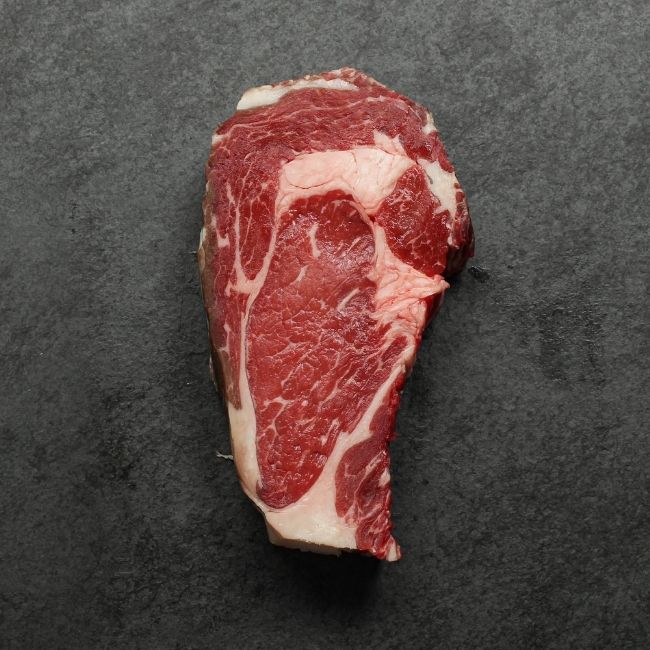 overhead view of the bottom of a raw dry aged rib eye steak