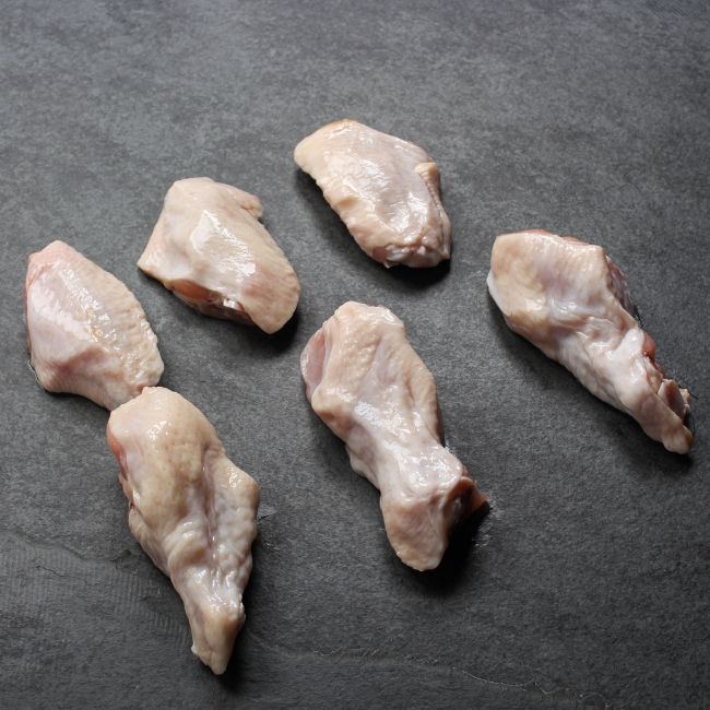 angled view of raw chicken wings - drums and flats