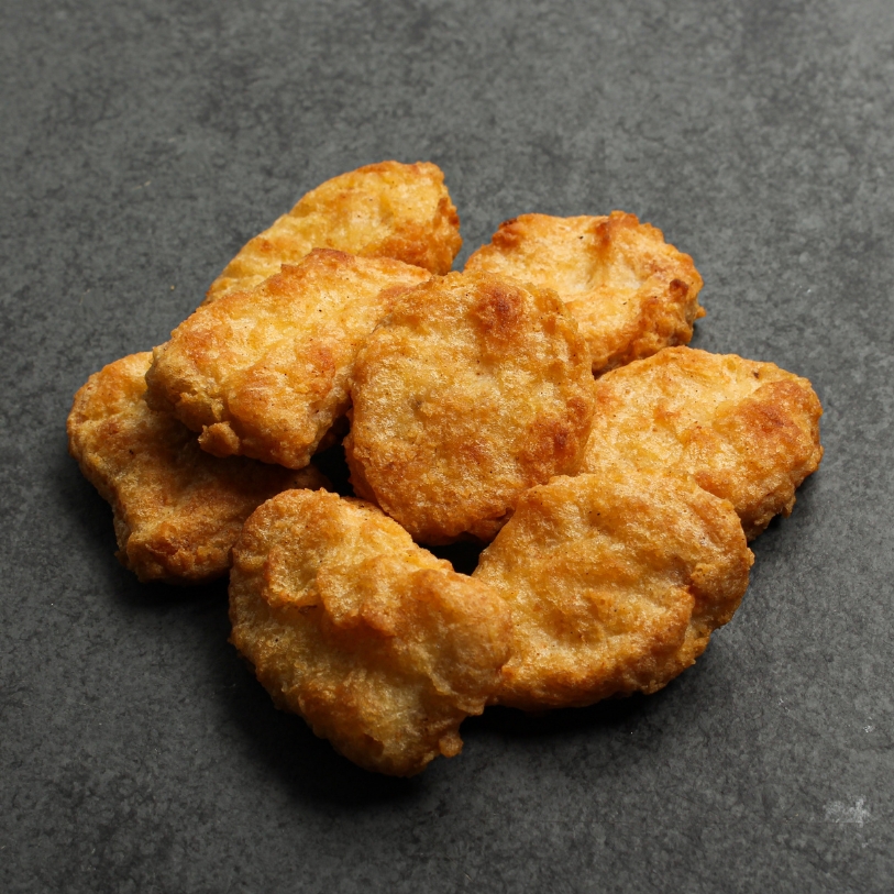 Overhead view of cooked Chicken Fritters on a black slate.