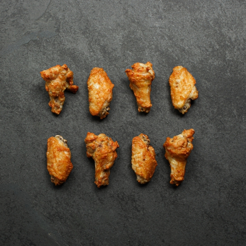 Overhead image of eight, prepared fully cooked chicken wings
