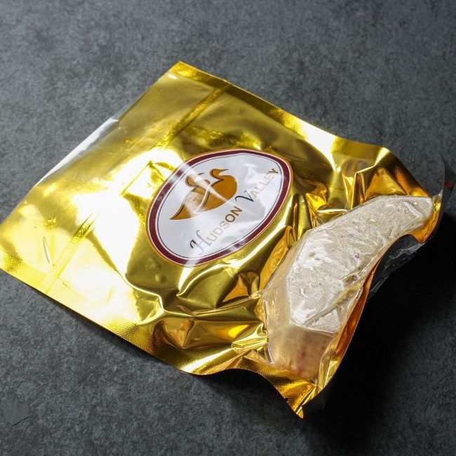 angled view of a vacuum-packaged slice of raw foie gras