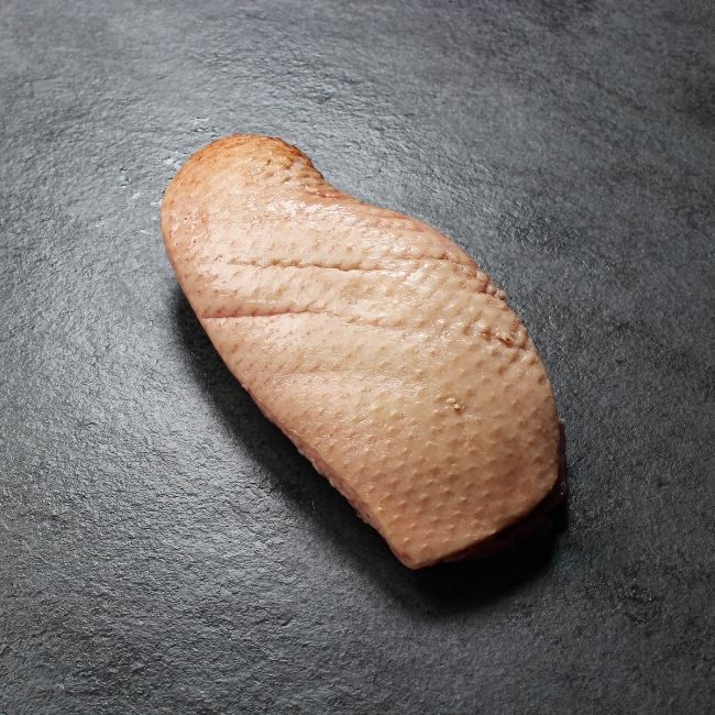 angled view of the fatty side of a piece of raw duck magret