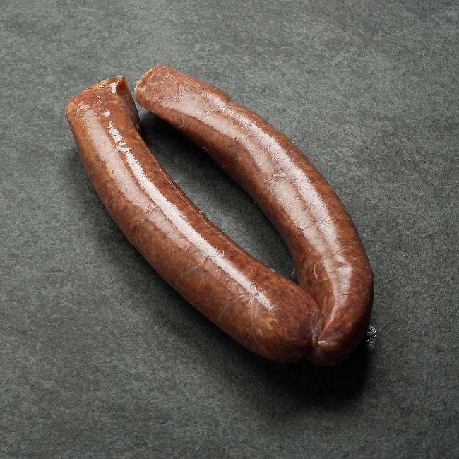 angled view of two raw Iberico pork and cranberry sausages