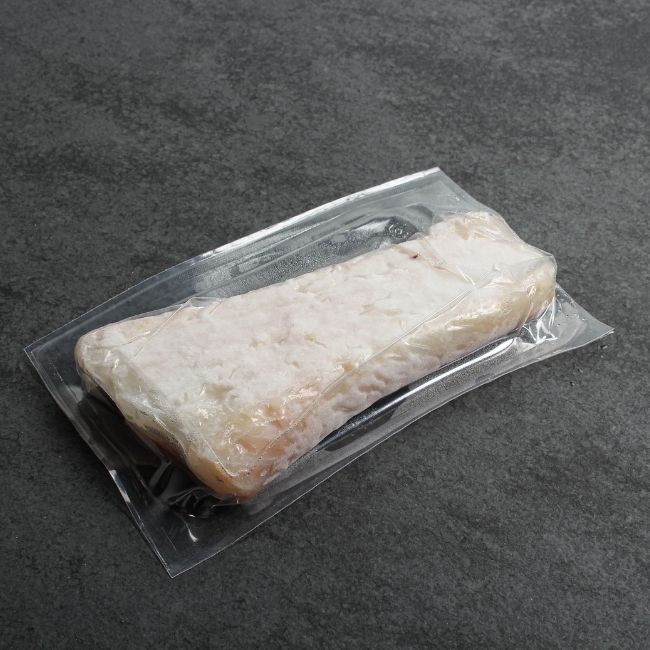 angled view of a vacuum-packaged piece of frozen Icelandic cod