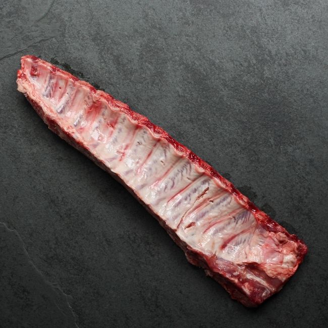 overhead image of the underside of a raw rack of pork back ribs