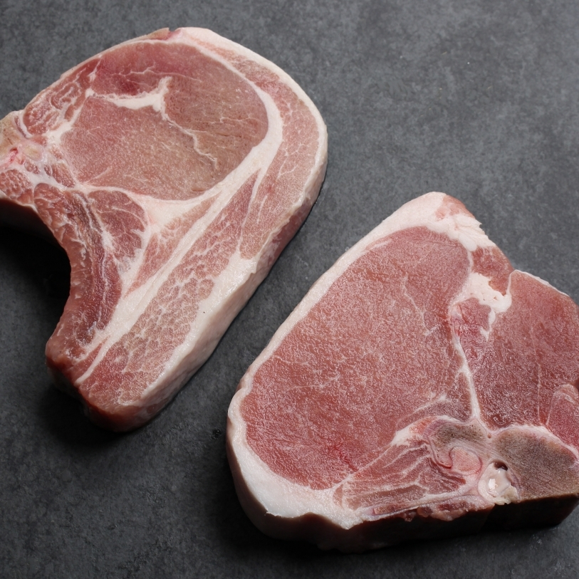 Angled image of uncooked bone-in pork chop sourced in Canada.
