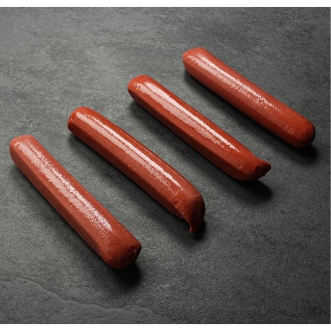 angled view of four raw wagyu beef frankfurters