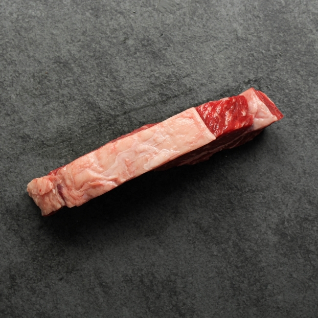 Side view of a raw New York steak fat cap.