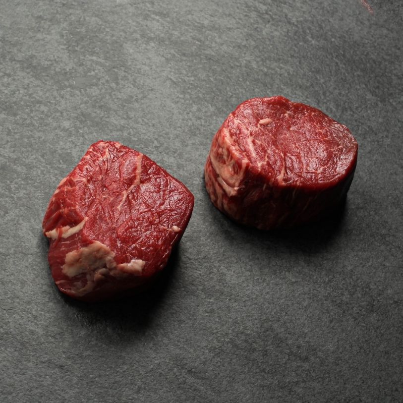 angled image of two raw beef filet mignon steaks