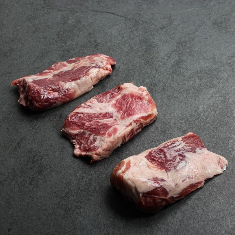 angled view of three raw pieces of Iberico pork pluma