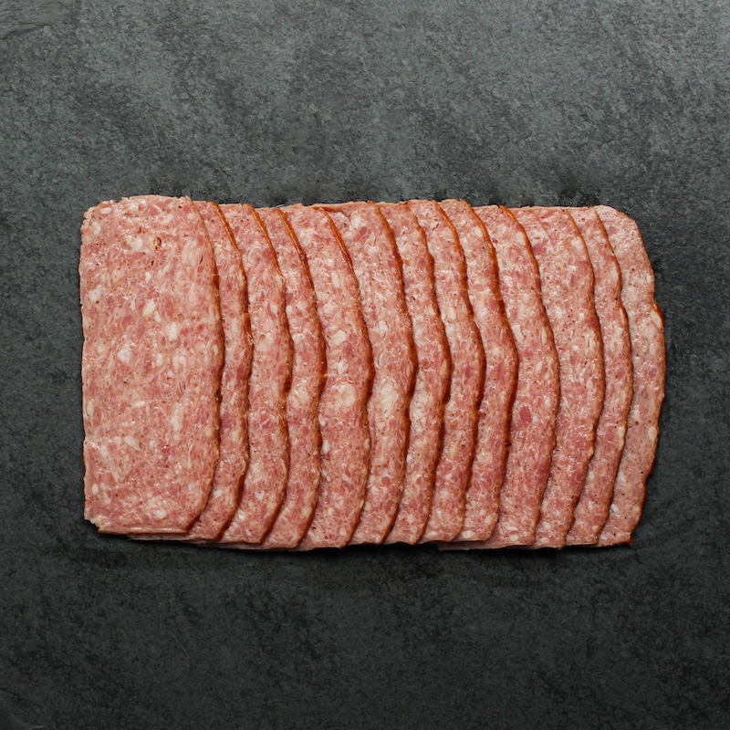 overhead view of raw turkey bacon splayed out on a piece of black slate