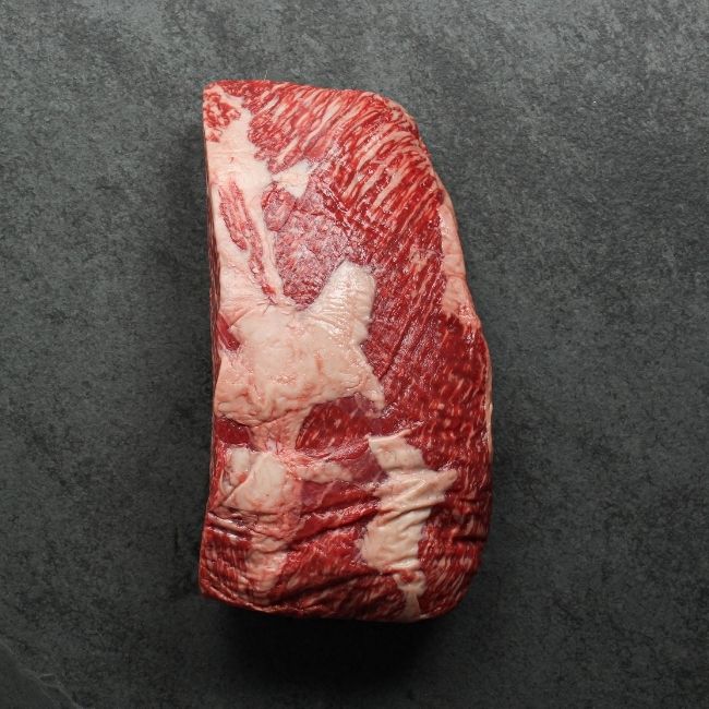 angled view of a richly marbled raw wagyu beef sirloin roast