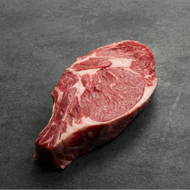 angled view of raw bone in rib steak.