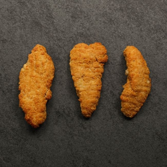 overhead view of cooked golden-brown, crispy chicken fingers